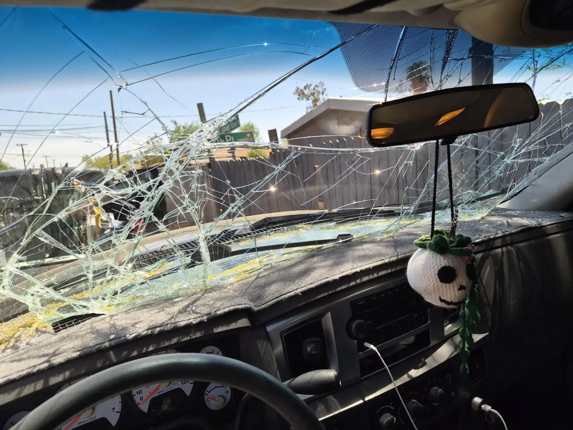 View from inside a car with a severely cracked windshield before replacement