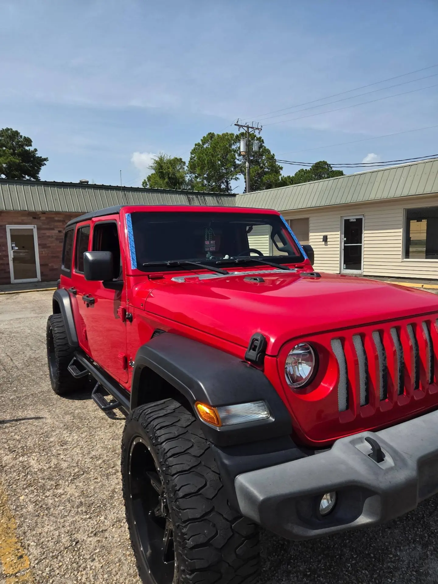 Red Jeep Gladiator Rubicon with a freshly installed windshield